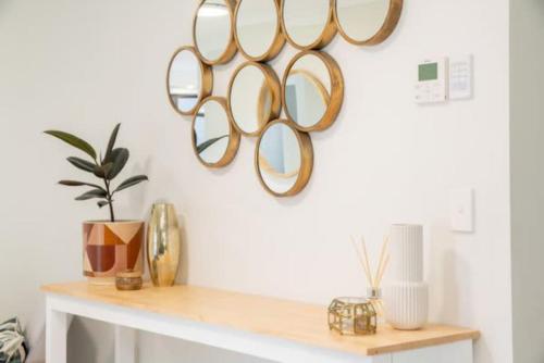 a room with a table with three mirrors on the wall at Mooloolaba Escape to Mooloolaba & Feel At Home in Style in Mooloolaba
