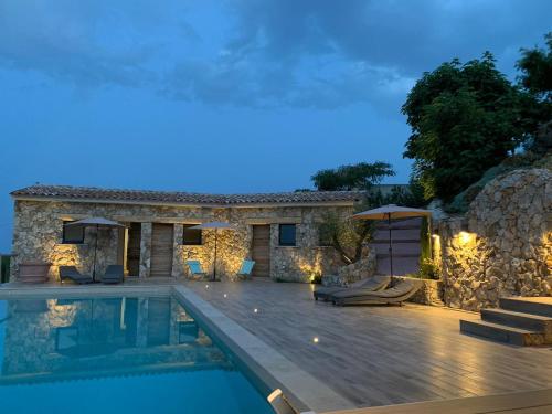 une villa avec une piscine la nuit dans l'établissement U CASEDDU- Villa piscine privée chauffée- vue mer- clim-wifi, à Sari-Solenzara