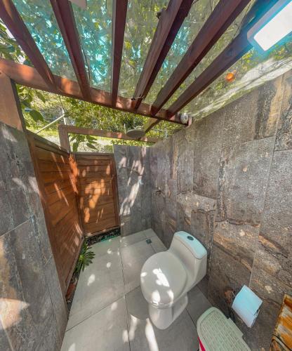 a bathroom with a toilet in a stone wall at All Natural Glamping in Copacabana