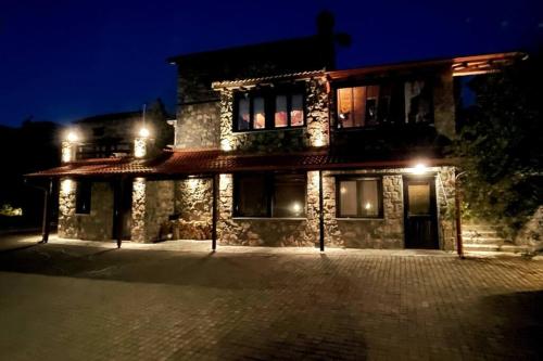 a stone house at night with lights at Blessings Chalet στον Παλαιό Άγιο Αθανάσιο με Τζάκι, Barbeque, μεγάλη αυλή και υπέροχη θέα in Palaios Agios Athanasios