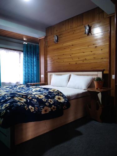 a bedroom with a bed with a wooden wall at Divine Bliss Homestay in Darjeeling