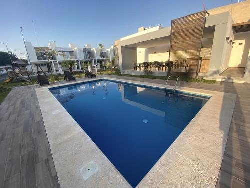 a swimming pool in front of a house at Casa familiar cerca de la playa con terraza privada in Cancún