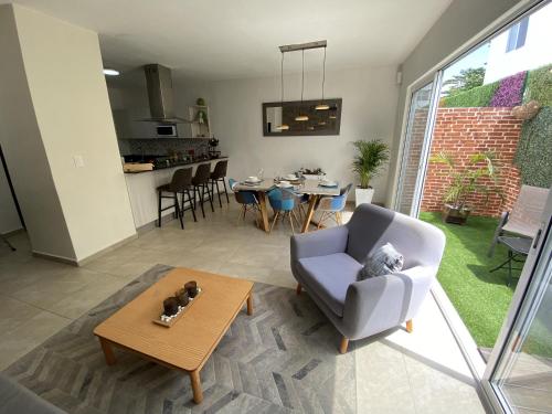 a living room with a couch and a table at Casa familiar cerca de la playa con terraza privada in Cancún