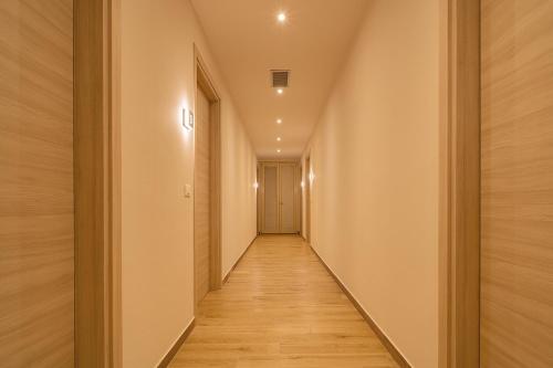 a hallway with wood floors and a long corridor at Le Alpi bed&living in Cividate Camuno