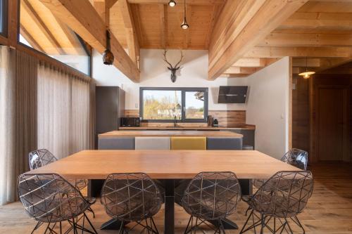 une salle à manger avec une table et des chaises en bois dans l'établissement Chalet Mana, tout confort avec spa et sauna, à Gérardmer