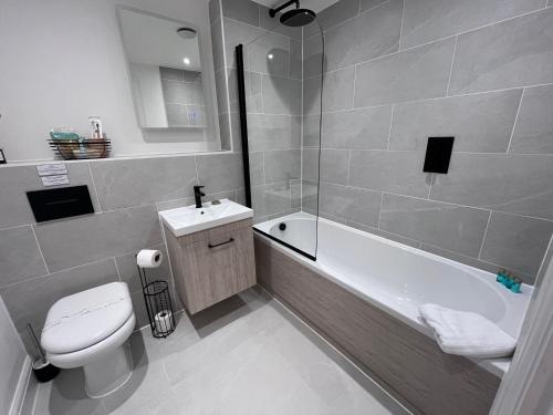 a bathroom with a tub and a toilet and a sink at Aurora Ashley Cross in Poole