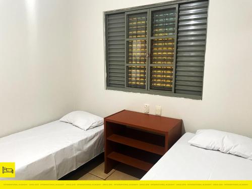 2 łóżka pojedyncze w pokoju z oknem w obiekcie I9 CT - Casa de Temporada Empresarial - Agrishow w mieście Ribeirão Preto