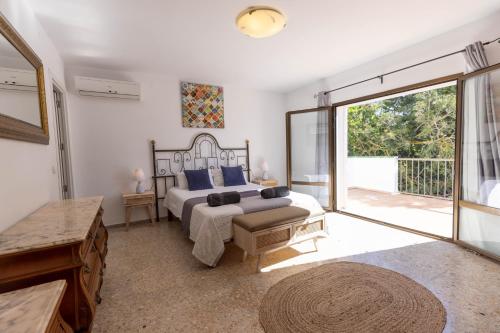 a bedroom with a bed and a large sliding glass door at Villa Carvi in San Antonio Bay