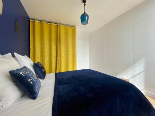 - une chambre avec un lit et un rideau jaune dans l'établissement Mon Saint-Patrice by Melrose, à Bayeux