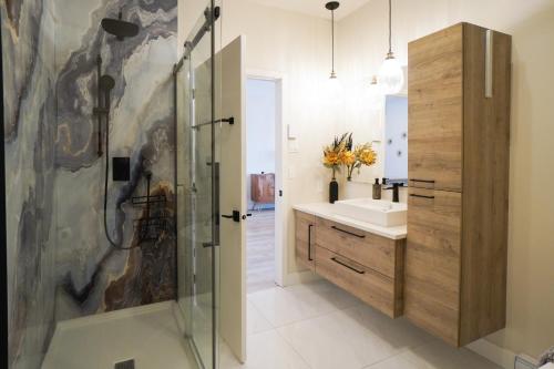 a bathroom with a shower and a sink at Le Riverain - Condo neuf au bord de l'eau in Shawinigan