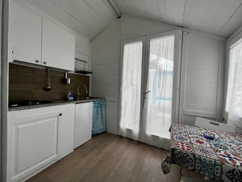 a kitchen with white cabinets and a bed in a room at Camping Car Palmasera in Cala Gonone