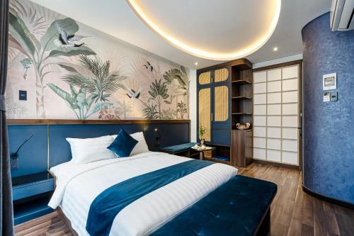 a bedroom with a blue and white bed and a wall mural at KunKin Garden Aparthotel in Ho Chi Minh City