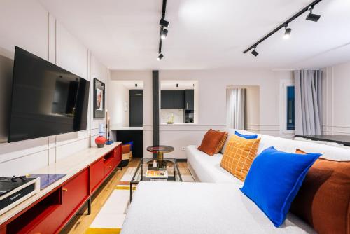 un soggiorno con divano bianco e TV a schermo piatto di Stylish 4 suites +patio luxury apartment Gran Via a Madrid