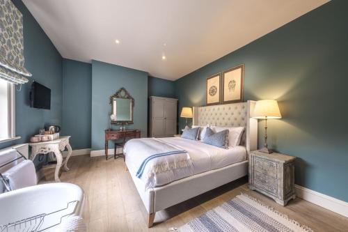 Schlafzimmer mit blauen Wänden, einem Bett und einer Badewanne in der Unterkunft The Packhorse Inn in Newmarket