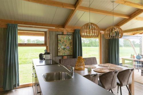 eine Küche mit einem Waschbecken und einem Tisch mit Stühlen in der Unterkunft Landrijk De Reesprong boerderij in Haaksbergen