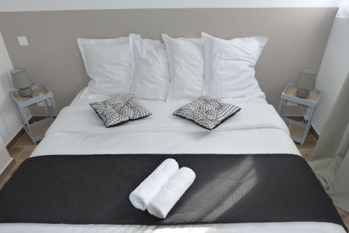 a bed with two towels and two pillows on it at Mini villa T3 climatisée, vue mer, cosy & moderne in Olmeto