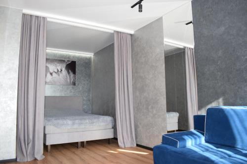 um quarto com uma cama e um sofá azul em Дизайнерські апартаменти в ЖК DreamTown 10б em Lutsk