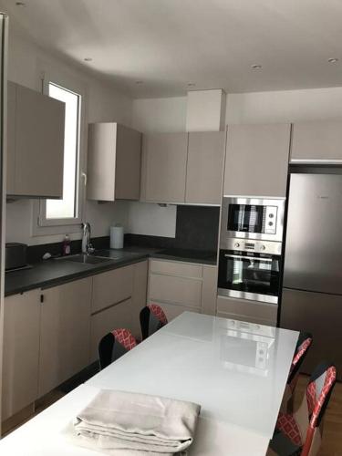 - une cuisine avec une table blanche et un comptoir dans l'établissement Saint Raphaël plage et centre ville 10 mn à pied, à Saint-Raphaël