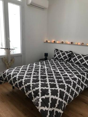 - une chambre avec une couette en noir et blanc sur un lit dans l'établissement Saint Raphaël plage et centre ville 10 mn à pied, à Saint-Raphaël