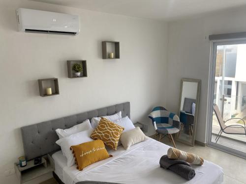 een bed met kussens in een slaapkamer bij Casa familiar cerca de la playa con terraza privada in Cancun