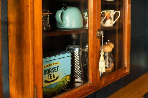 un armario con una caja de té cocinado en él en Astronomer Shepherd's hut, en Beaminster