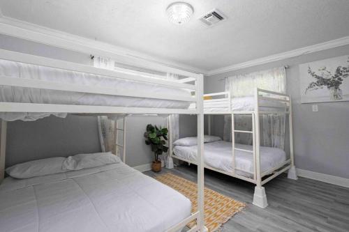 a bedroom with two bunk beds in it at Cottage in the Gardens! in Miami Gardens
