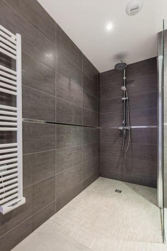 une salle de bain avec une douche avec une porte vitrée dans l'établissement T2 d'exception 100m plage terrasse vue mer et montagnes, à Propriano