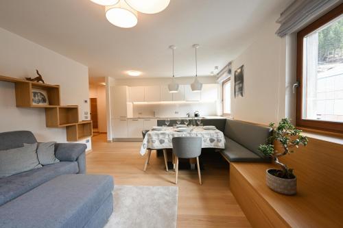 uma sala de estar com um sofá e uma mesa de jantar em Casa al Parco Deluxe em Canazei