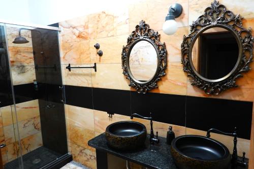 a bathroom with two mirrors and a sink at Aladin Comfort Country Rooms in Campinho