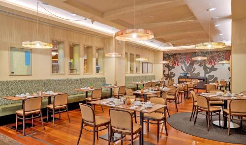 un ristorante con tavoli e sedie in una stanza di Pestana Chelsea Bridge Hotel & SPA a Londra