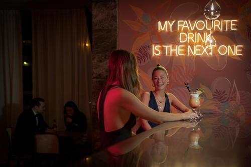 two women sitting at a table with a drink at Pestana Chelsea Bridge Hotel & SPA in London