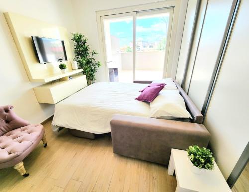 a bedroom with a bed and a couch and a window at Quela Apartment - Pietralata in Rome
