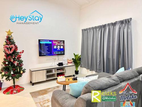 Sala de estar con árbol de Navidad y TV en Klebang Villa 17Pax PrivateSwimmingPool TownArea By Heystay Management en Melaka