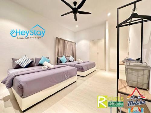 una camera da letto con due letti e un ventilatore a soffitto di Klebang Villa 17Pax PrivateSwimmingPool TownArea By Heystay Management a Malacca