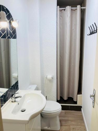 une salle de bain avec des toilettes blanches et un lavabo dans l'établissement La Timonerie - Le Marquenterre 101, accès plage à 50 mètres classé 3 étoiles, à Fort-Mahon-Plage