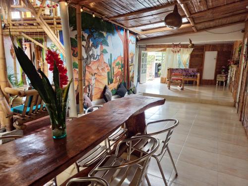Cette chambre dispose d'une table avec des chaises et d'un vase avec des fleurs. dans l'établissement Tatacoa Star Eco Hotel, à Villavieja