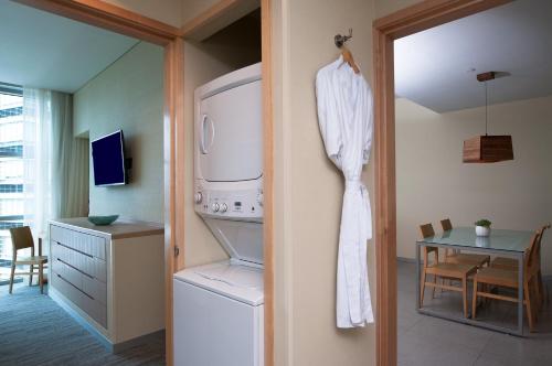 une cuisine avec un lave-linge, un sèche-linge et une table dans l'établissement Stadia Suites Mexico City Santa Fe, à Mexico