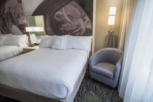 a hotel room with a bed and a chair at Courtyard by Marriott Hickory in Hickory