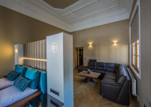 a living room with a couch and a table at Parkhotel Plauen in Plauen