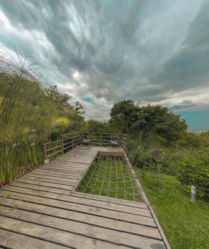 a wooden boardwalk with a view of the ocean at All Natural Glamping in Copacabana