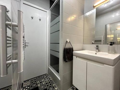 uma casa de banho branca com um lavatório e um chuveiro em Logement Neuf - Proximité Centre em Bourges