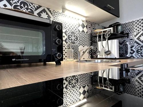 uma cozinha com um micro-ondas no balcão em Logement Neuf - Proximité Centre em Bourges