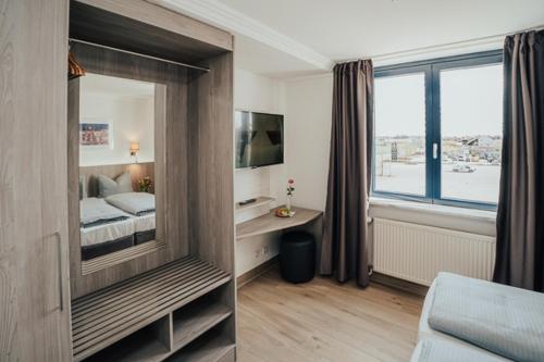 a bedroom with a bed and a large window at Lechpark Hotel in Untermeitingen