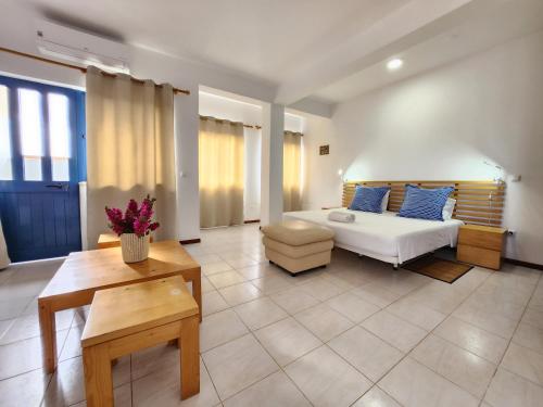 a large living room with a bed and a table at Txada Hostel in Praia
