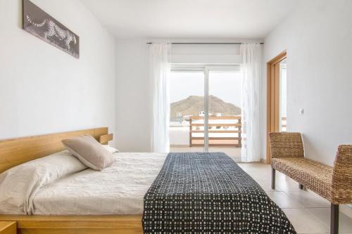 サン・ホセにあるVilla Paraísoのベッドルーム1室(ベッド1台、椅子、窓付)