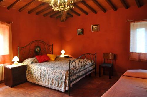 a bedroom with a bed in a red wall at Casa al Fico in Castelnuovo deʼ Sabbioni