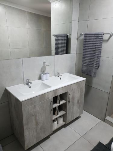 a bathroom with a sink and a mirror at Haleys Guest House in Benoni