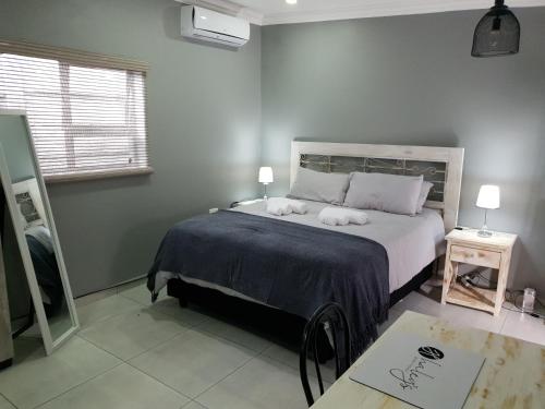 una camera con un letto con due cuscini sopra di Haleys Guest House a Benoni