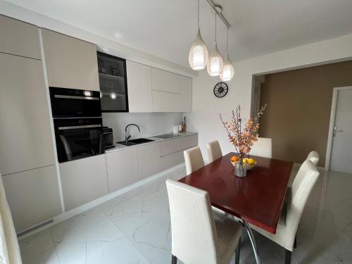 a kitchen with a wooden table and white cabinets at Apartmani Rašić in Bibinje