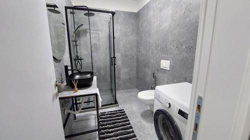 ein Bad mit einer Dusche, einem WC und einem Waschbecken in der Unterkunft Amelja's Apartment in Shkodra